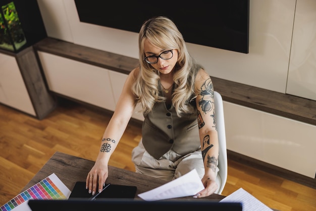 Jovem designer freelancer parecendo pensativa enquanto trabalhava no computador no conforto de sua casa.