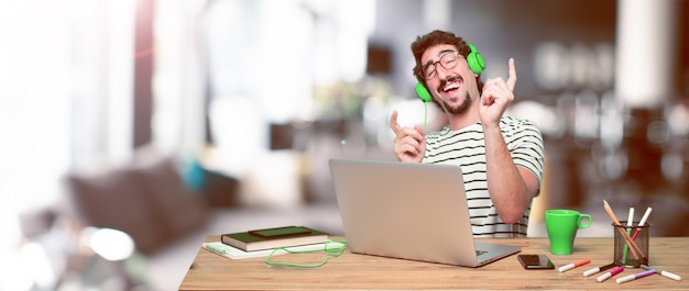 Jovem designer gráfico louco em uma mesa com um laptop