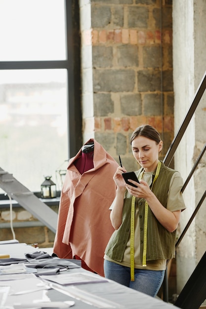 Jovem designer sério de coleção de moda pesquisando ideias online