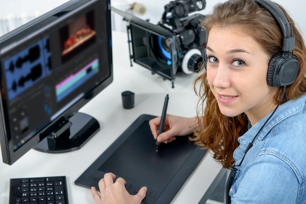 Jovem designer usando mesa digitalizadora para edição de vídeo