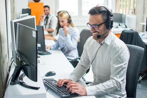 Foto jovem despachador de suporte técnico com fone de ouvido falando com o cliente no call center