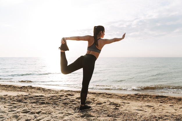 Jovem desportista a fazer exercício na praia