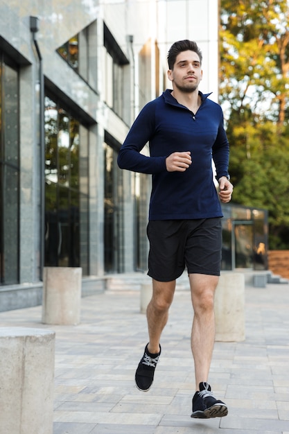 Jovem desportista confiante a correr na cidade