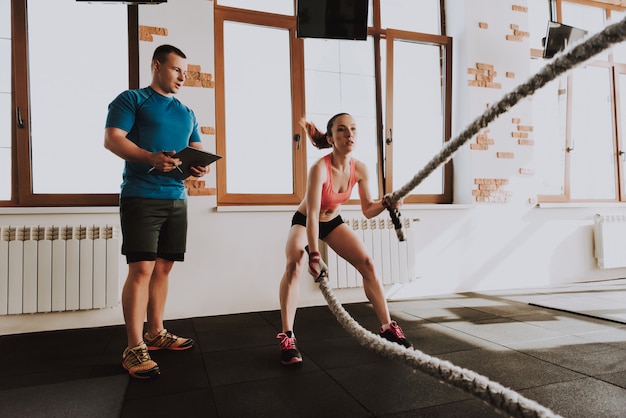 Jovem desportista é exercícios no ginásio com treinador