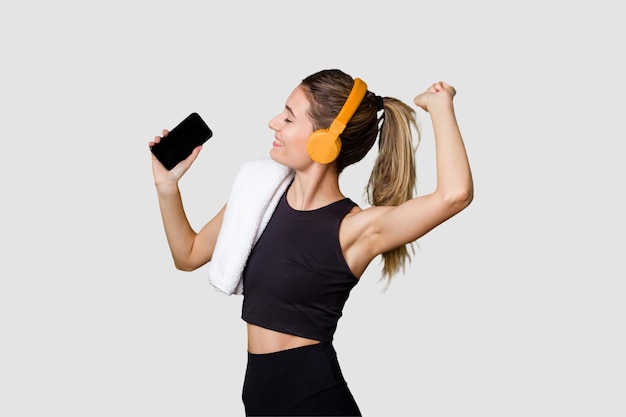 Foto jovem desportista ouvindo música motivada e focada segurando o telefone