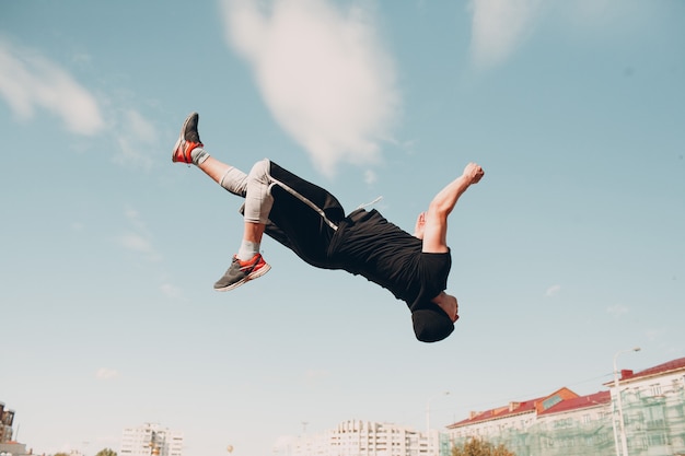 Foto jovem desportivo fazendo parkour na rua da cidade.