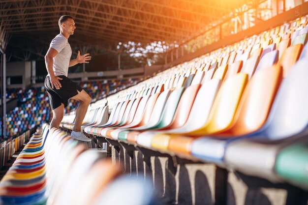 Foto jovem desportivo subindo as escadas no estádio