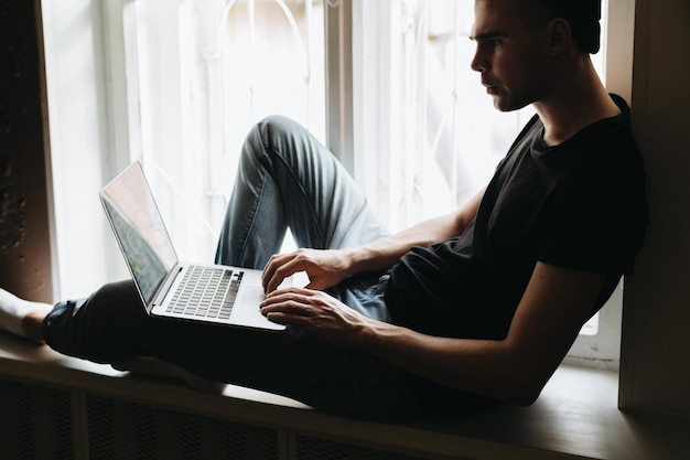 Jovem digitando algo em um laptop