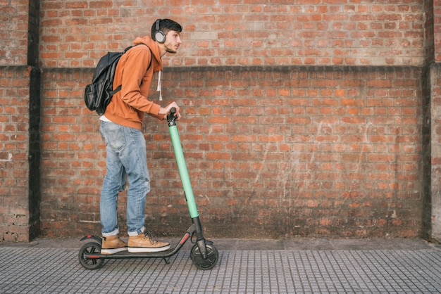 Jovem dirigindo scooter elétrico.