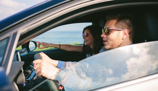 Jovem dirigindo um carro com a namorada