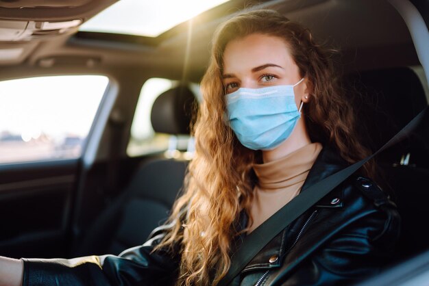 Jovem dirigindo um carro usando uma máscara médica durante uma epidemia Isolamento de transporte Covid2019