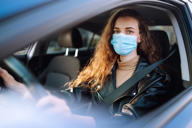 Jovem dirigindo um carro usando uma máscara médica durante uma epidemia Isolamento de transporte Covid2019