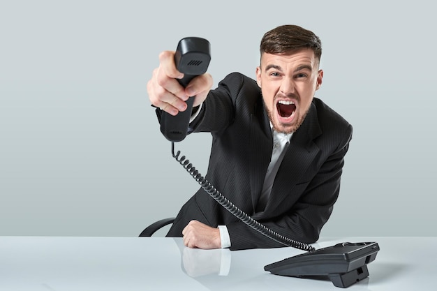 Foto jovem disca o número de telefone enquanto está sentado no escritório