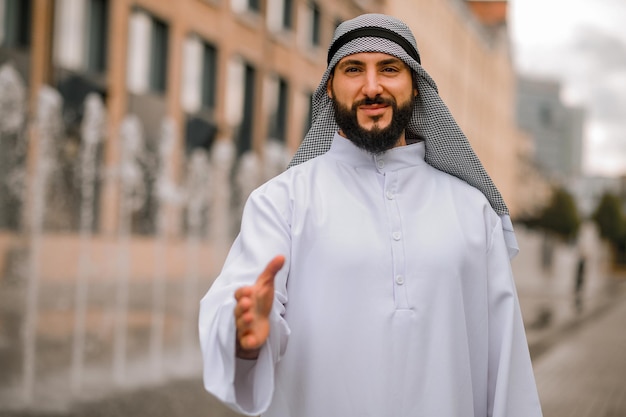 Jovem do Oriente Médio esticando a mão para um aperto de mão