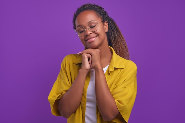 Jovem doce mulher afro-americana com olhos fechados de sorriso e cabeça inclinada