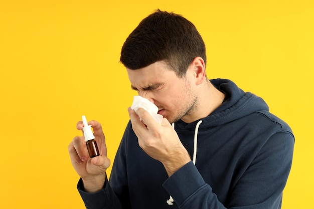 Jovem doente em fundo amarelo, conceito de frio sazonal