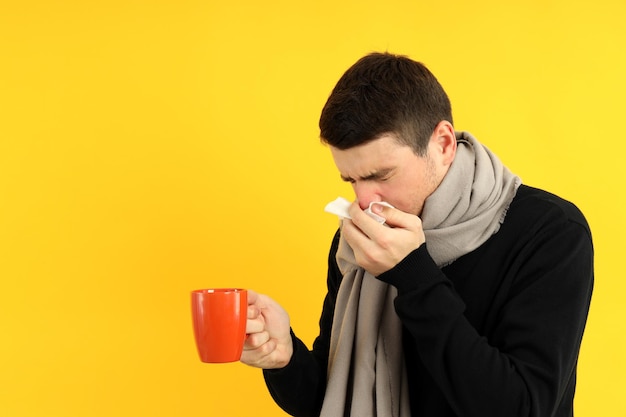 Jovem doente em fundo amarelo, conceito de frio sazonal