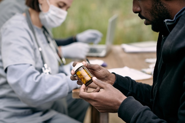 Jovem doente segurando um frasco com comprimidos prescritos pelo médico
