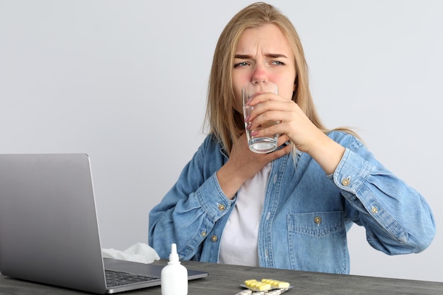 Jovem doente sentada no local de trabalho, conceito de frio sazonal