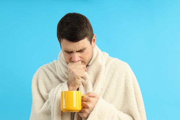 Jovem doente sobre fundo azul, conceito de frio sazonal