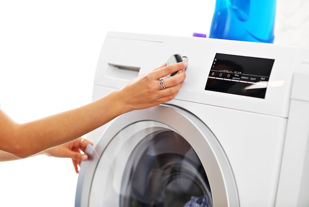 jovem dona de casa com roupa suja ao lado da máquina de lavar