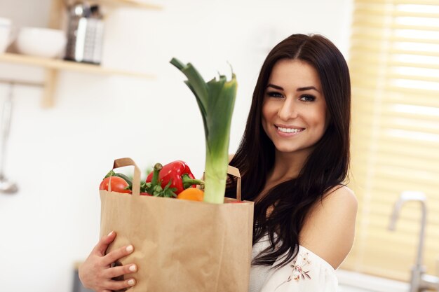 jovem dona de casa sorridente em cozinha moderna