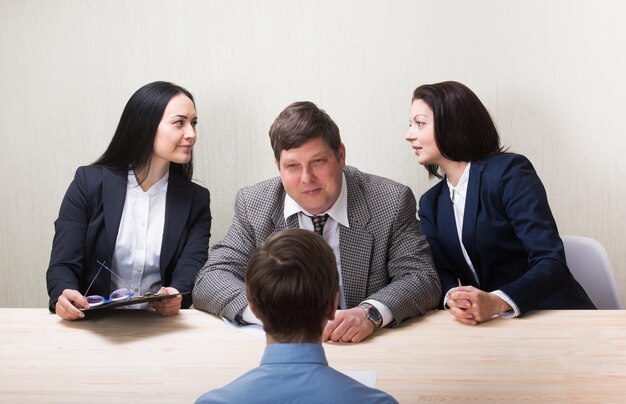 Jovem durante entrevista de emprego e membros de gestores