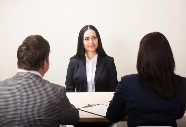 Foto jovem durante entrevista de emprego e membros de gestores