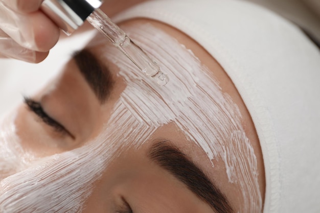 Jovem durante o procedimento de peeling facial no salão de beleza