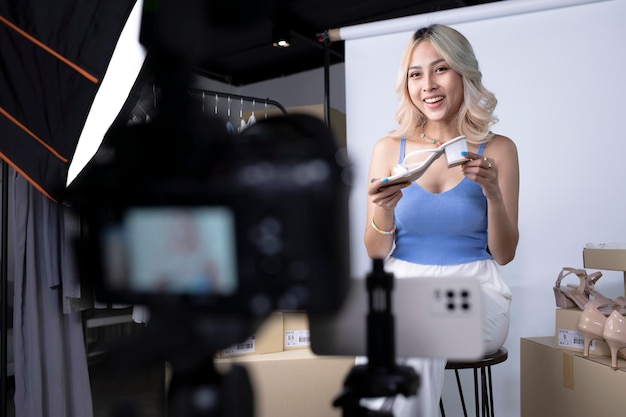 Jovem e atraente blogueira asiática ou vlogger olhando para a câmera revendo o produto Empresária moderna usando mídias sociais para marketing Influenciador on-line de negócios no conceito de mídia social