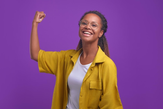 Foto jovem e atraente mulher afro-americana mostrando bíceps no braço e rindo