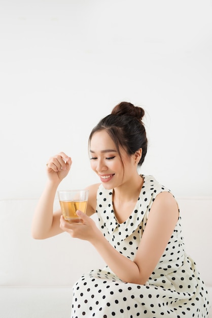 Jovem e atraente mulher asiática bebendo chá quente