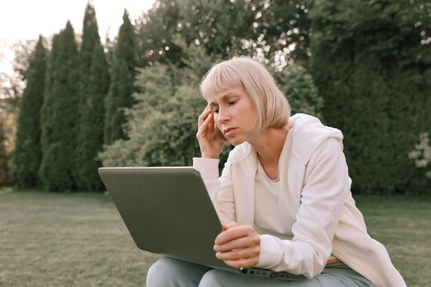 Jovem e bela empresária trabalhando em um laptop freelancer trabalha na natureza Empresária no trabalho ao ar livre