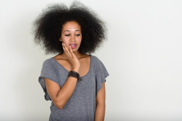 jovem e bela mulher africana com cabelo afro em branco