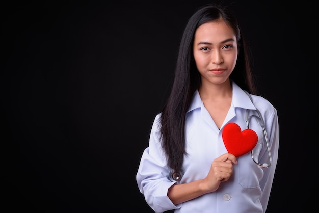 jovem e bela mulher asiática contra parede preta