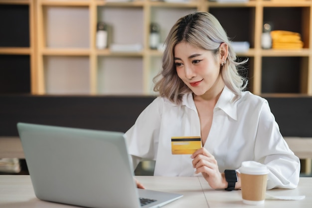 Jovem e bela mulher asiática sorrindo e feliz apresentando compras on-line de cartão de crédito Compras on-line ecommerce internet bankingxA