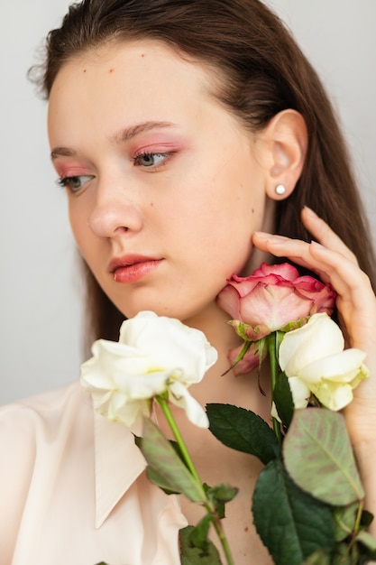 Jovem e bela mulher cheirando um buquê de rosas vermelhas. foto do interior da moda de uma bela mulher sorridente com cabelo escuro segurando um grande buquê de rosas vermelhas no dia dos namorados