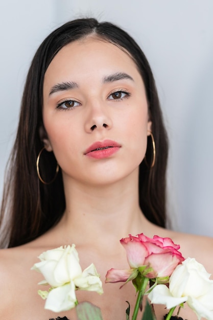 Jovem e bela mulher cheirando um buquê de rosas vermelhas. foto do interior da moda de uma bela mulher sorridente com cabelo escuro segurando um grande buquê de rosas vermelhas no dia dos namorados