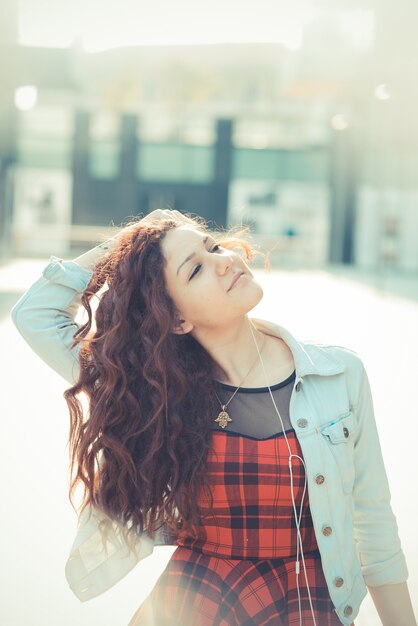 jovem e bela mulher de hipster com cabelo encaracolado vermelho