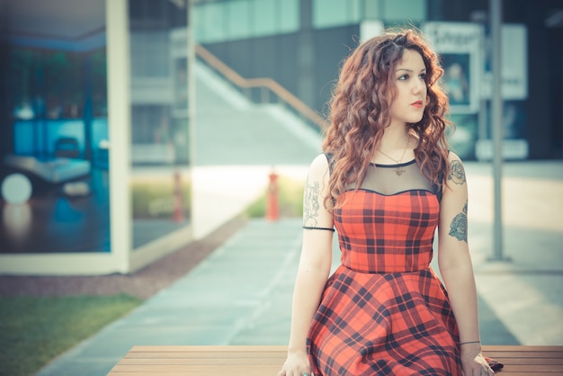 jovem e bela mulher de hipster com cabelo encaracolado vermelho