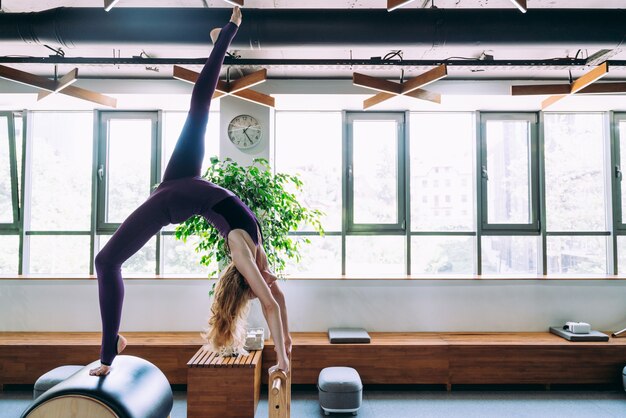 Foto jovem e bela mulher fazendo reabilitação física e pilates na academia