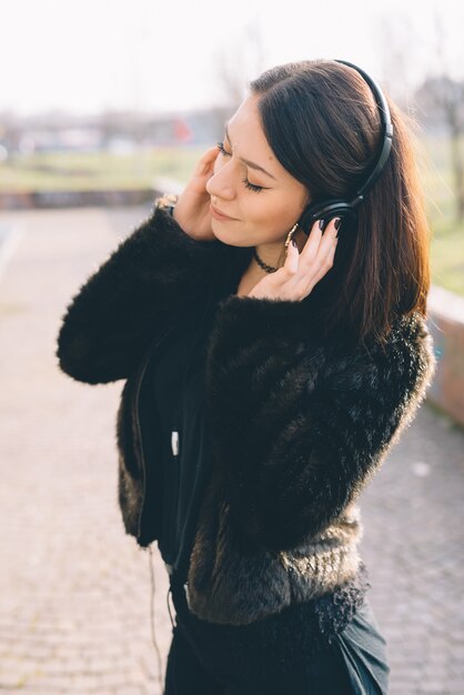 jovem e bela mulher ouvindo música com fones de ouvido