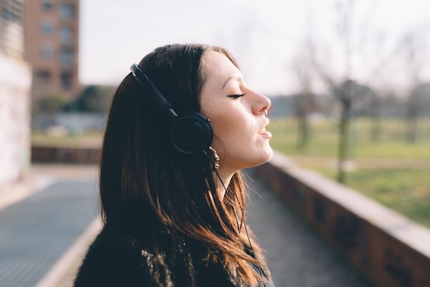 Jovem e bela mulher ouvindo música com fones de ouvido