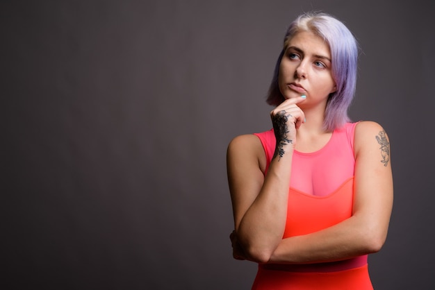 jovem e bela mulher rebelde com cabelos coloridos e vestido vermelho neon