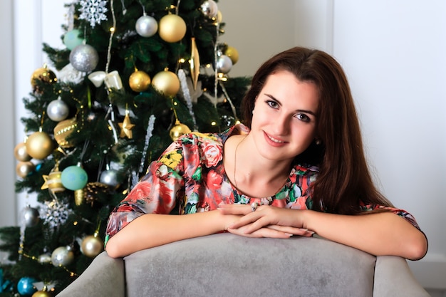 Jovem e bela mulher sorridente em um quarto decorado com Natal