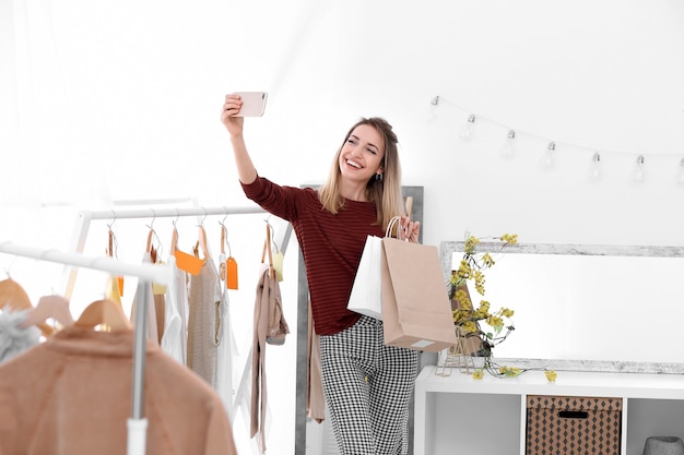 Jovem e bela mulher tirando uma selfie enquanto fazia compras na loja