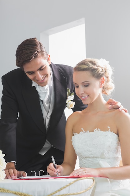 Foto jovem e bonita assinatura do registro de casamento