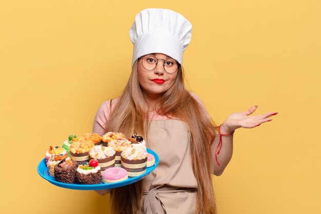 Jovem e bonita expressão confusa conceito de culinária de padeiro