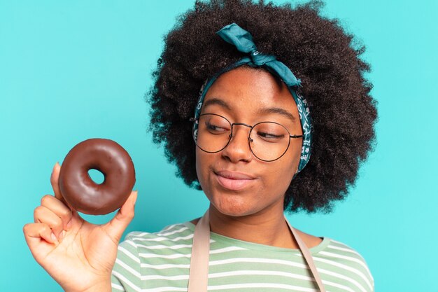 Foto jovem e bonita mulher afro com um donut