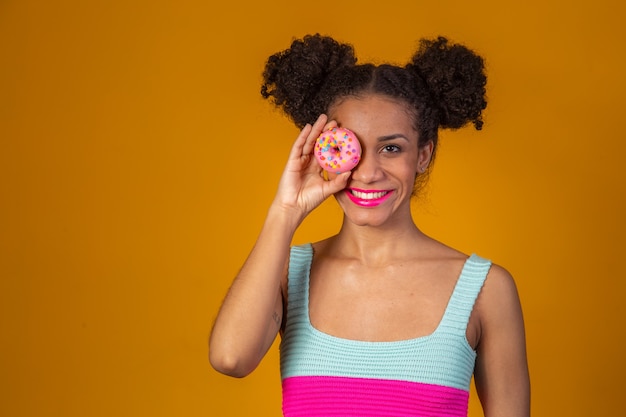 Jovem e bonita mulher afro com um donut